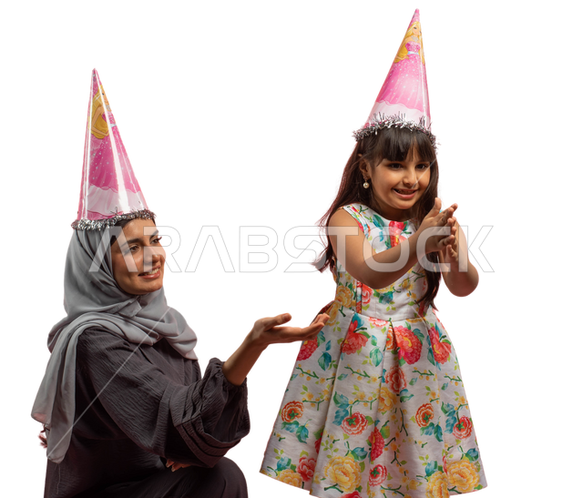 Happy family holidays and occasions, a portrait of a Saudi Arabian Gulf mother wearing a Christmas hat with her daughter, playing with flying and scattered