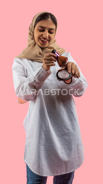 Facial gestures indicating enjoyment of cosmetic products, the concept of femininity and attention to the external appearance, modern women's cosmetics, marketing of cosmetic products, a portrait of a Saudi Arabian Gulf girl holding in her hand cosmetics 