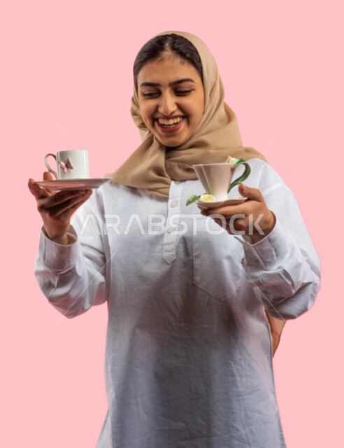 Enjoying shopping in household utensils stores and stores, gestures indicating admiration for household items, a portrait of a Saudi Arabian Gulf girl holding decorated ceramic glassware in her hand, restaurant supplies and equipment, tea and coffee cups,