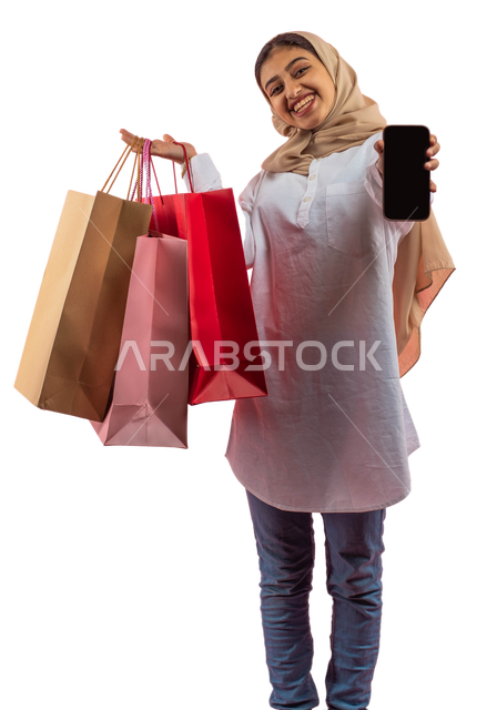 Safe electronic purchase, facial gestures indicating enjoyment of shopping, a portrait of a smiling Saudi Arabian Gulf woman in casual attire carrying