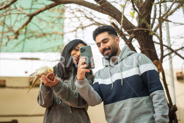 Spending fun family times in the Riyadh safari season, documenting moments by taking souvenir photos with wild animals in the nature reserve, a Saudi Gulf Arab couple touring the zoo in the Kingdom of Saudi Arabia