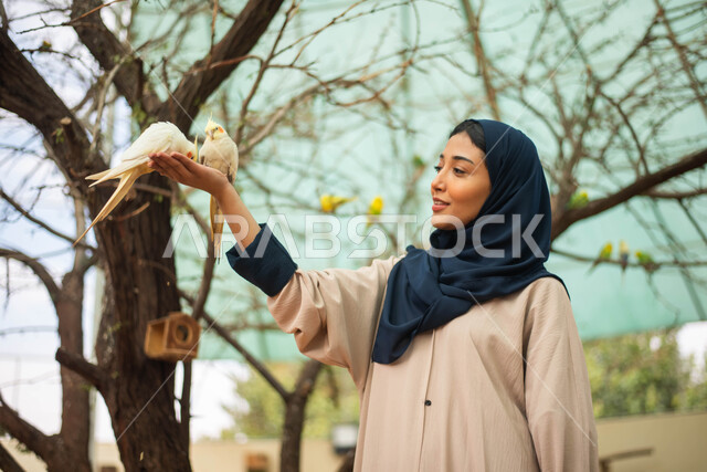 مزارع تربية الطيور ، ايماءات وجه تدل على السعادة والاستمتاع، سيدةعربية  سعودية خليجية محجبة في زيارة لحديقة الحيوانات في السعودية ، أنشطة ترفيهية مع الطيور، طيور في المحمية الطبيعية ،  أماكن سياحية .