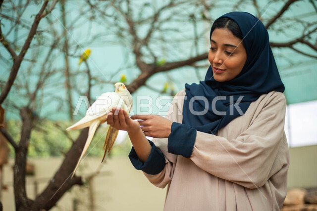 مزارع تربية الطيور ، ايماءات وجه تدل على السعادة والاستمتاع، سيدةعربية  سعودية خليجية محجبة في زيارة لحديقة الحيوانات في السعودية ، أنشطة ترفيهية مع الطيور، طيور في المحمية الطبيعية ،  أماكن سياحية .