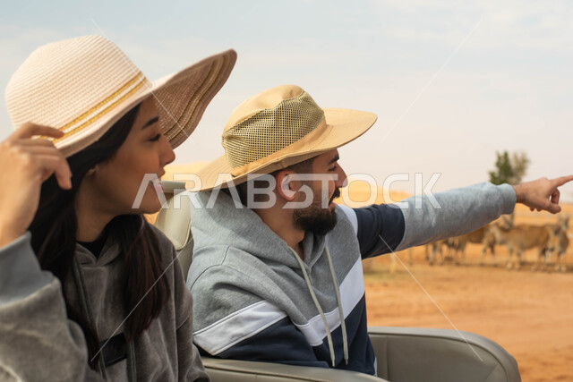  إيماءات يدين و وجه تدل على السعادة و الاستمتاع, قضاء أوقات ممتعة في المحمية الطبيعية ,   زوجان عربيان خليجيان سعوديان يقومان بجولة سياحية في حديقة الحيوانات في المملكة العربية السعودية, فعاليات ترفيهية عائلية في سفاري الرياض.