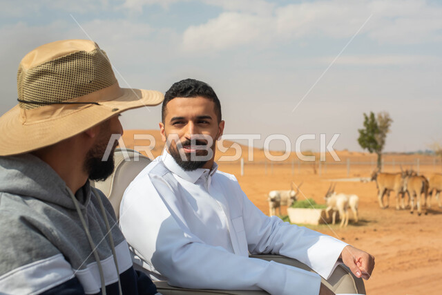 قضاء أوقات ممتعة برفقة الأصدقاء,  شابان عربيان خليجيان سعوديان يقومان بجولة سياحية في حديقة الحيوانات في المملكة العربية السعودية, ايماءات وجه تدل على السعادة و الاستمتاع, أنشطة و  فعاليات ترفيهية عائلية في سفاري الرياض.