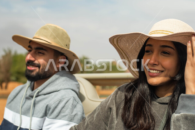 قضاء أوقات ممتعة و مسلية, صورة مقربة لزوجان عربيان خليجيان سعوديان يقومان بجولة سياحية في المملكة العربية السعودية, ايماءات وجه تدل على السعادة و السرور, فعاليات و أنشطة ترفيهية في موسم سفاري في الرياض.