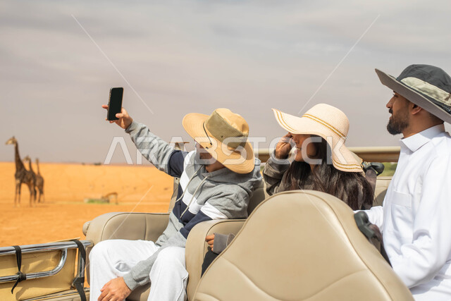 Taking memorial selfies and documenting the fun moments, family entertainment events and activities, a Saudi Gulf Arab family on a tour of the zoo in the Kingdom of Saudi Arabia, the Riyadh Season safari event.