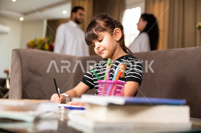 تلميذة سعودية خليجية تدرس في المنزل و تؤدي واجباتها المدرسية ، التعلم عن بعد ، مفهوم التعليم عبر الانترنت ، التعليم المنزلي اثناء الحجر الصحي و تفشي فيروس كورونا ، العزلة الذاتية .