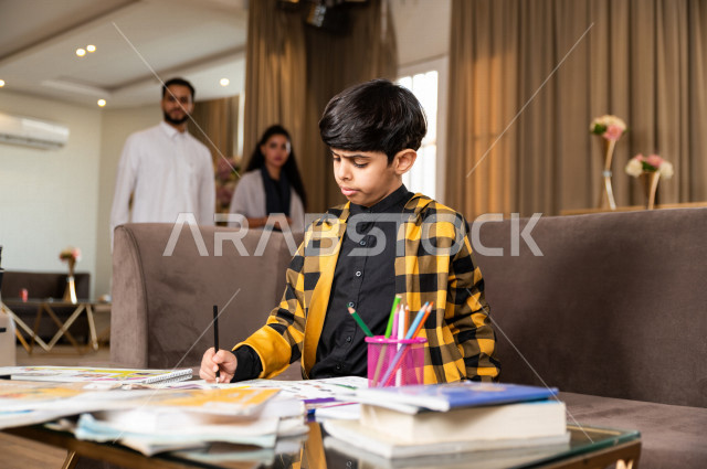 تلميذ سعودي خليجي يدرس في المنزل و يؤدي واجباته المدرسية ، التعليم عن بعد ، مفهوم التعليم عبر الانترنت ، التعليم المنزلي اثناء الحجر الصحي و تفشي فيروس كورونا ، العزلة الذاتية .