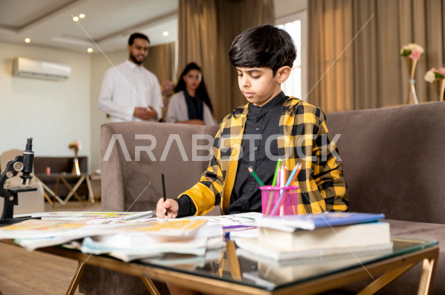 تلميذ سعودي خليجي يدرس في المنزل و يؤدي واجباته المدرسية ، التعليم عن بعد ، مفهوم التعليم عبر الانترنت ، التعليم المنزلي اثناء الحجر الصحي و تفشي فيروس كورونا ، العزلة الذاتية .