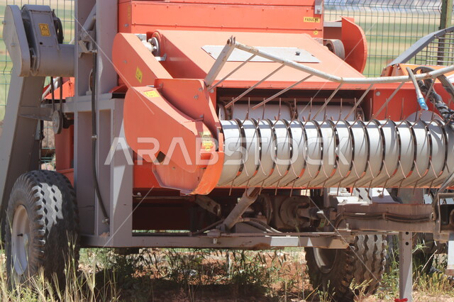 جرار الزراعة في حقل زراعي في المملكة العربية السعودية، صورة مقربة لآلة حصاد وتقليب التربة الزراعية، موسم الحصاد في احدى المزارع السعودية، انتاج محلي للمحاصيل الزراعية السعودية