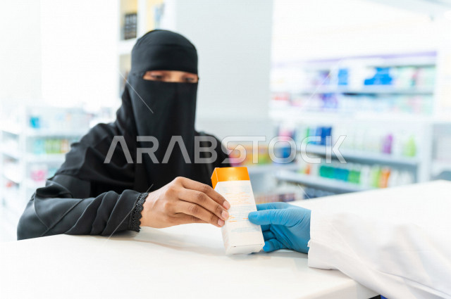 سيدة عربية خليجية سعودية تقوم بطلب الادوية من صيدلي خليجي يرتدي الكمامة للوقاية من فايروس كورونا ، اختيار الادوية والمنتجات الطبية ،شراء الادوية الموجودة في الوصفات الطبية  ، الاستفادة من الخدمات والرعاية الصحية 