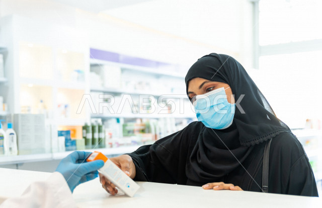 سيدة عربية خليجية سعودية ترتدي الكمامة الطبية للوقاية من فايروس كورونا ، اختيار الادوية والمنتجات الطبية ،شراء الادوية الموجودة في الوصفات الطبية  ، الاستفادة من الخدمات والرعاية الصحية 