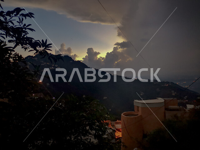 صورة ظلية لأغصان الشجر والنباتات الخضراء، الضباب فوق جبال الفيفاء في جازان في المملكة العربية السعودية وقت غروب الشمس، اماكن ومعالم سياحية مشهورة جنوب السعودية، البيوت والمباني السكنية الاثرية، القمم والمرتفعات الجبلية ,خلفية الطبيعة