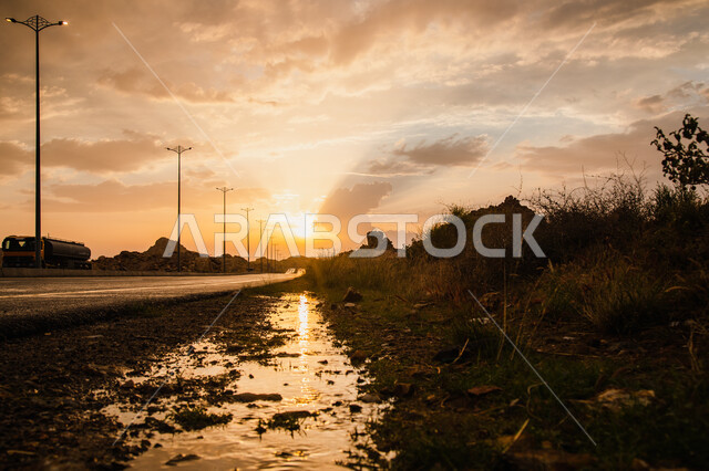 غروب الشمس في منطقة عسير في المملكة العربية السعودية, السماء المليئة بالغيوم, الطرق والشوارع المعبدة, اعمدة الانارة, خلفية الطبيعه .