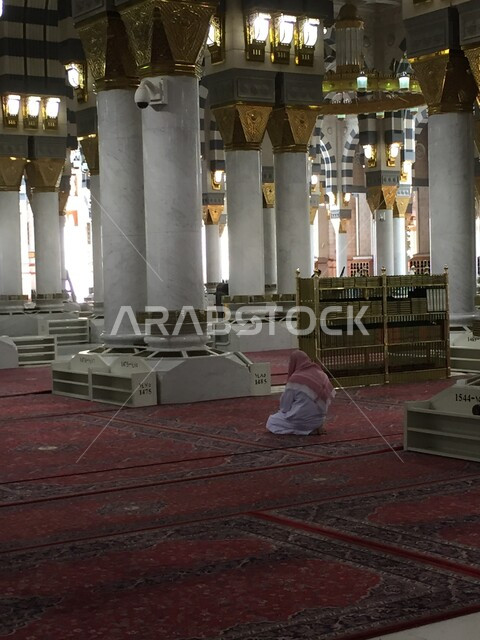 رجل عربي خليجي سعودي يرتدي الزي السعودي التقليدي يجلس داخل المسجد النبوي الشريف في المدينة المنورة في المملكة العربية السعودية، التصاميم و الزخارف الإسلامية، الفن الهندسي المعماري ، العبادة والتقرب الى الله، اسلاميات وعبادة، أماكن إسلامية مقدسة