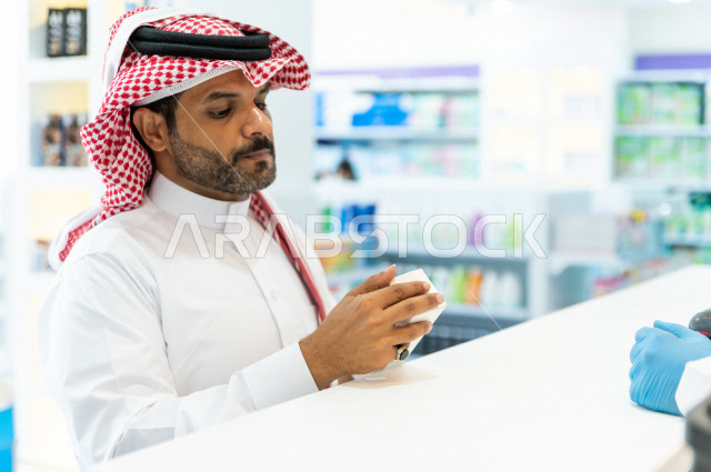 رجل عربي خليجي سعودي داخل الصيدلية ، وصف الادوية المطلوبة والحالة المرضية ، شراء الادوية والمستلزمات الطبية ،طلب الادوية الموجودة في الوصفة الطبية ،  الاستفادة من الخدمات الصحية