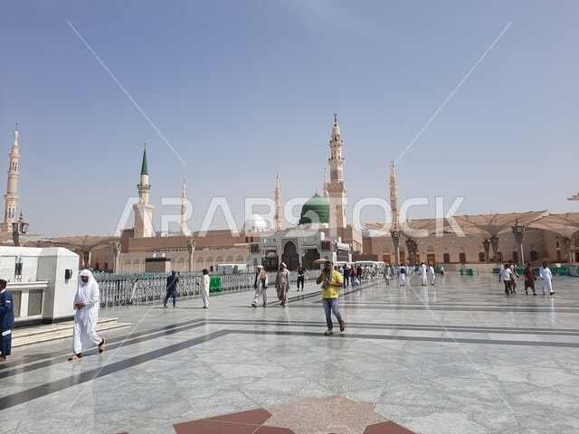 مجموعة من المصلين في ساحة المسجد النبوي الشريف في المدينة المنورة في المملكة العربية السعودية، أماكن مقدسة اسلامية، المظلات الالكترونية ,معالم دينية إسلامية,  العبادة والتقرب الى الله، الحرم النبوي الشريف،  المجمع الخارجي للمسجد النبوي في المدينة المنورة