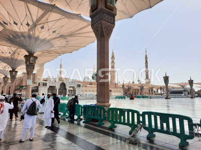 مجموعة من المصلين في ساحة المسجد النبوي الشريف في المدينة المنورة في المملكة العربية السعودية،المظلات الالكترونية ,معالم دينية إسلامية,  العبادة والتقرب الى الله، الحرم النبوي الشريف، أماكن إسلامية مقدسة، المجمع الخارجي للمسجد النبوي في المدينة المنورة