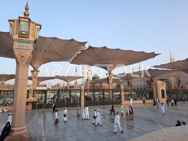 تجول المصلين في  المجمع الخارجي للمسجد النبوي في المدينة المنورة، المظلات الالكترونية في ساحة المسجد النبوي الشريف في المدينة المنورة في المملكة العربية السعودية، معالم دينية إسلامية,  العبادة والتقرب الى الله، الحرم النبوي الشريف، أماكن إسلامية مقدسة