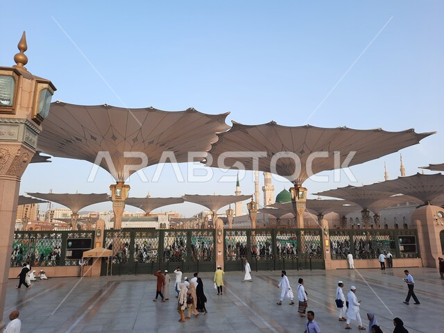 تجول المصلين في  المجمع الخارجي للمسجد النبوي في المدينة المنورة، المظلات الالكترونية في ساحة المسجد النبوي الشريف في المدينة المنورة في المملكة العربية السعودية، معالم دينية إسلامية,  العبادة والتقرب الى الله، الحرم النبوي الشريف، أماكن إسلامية مقدسة