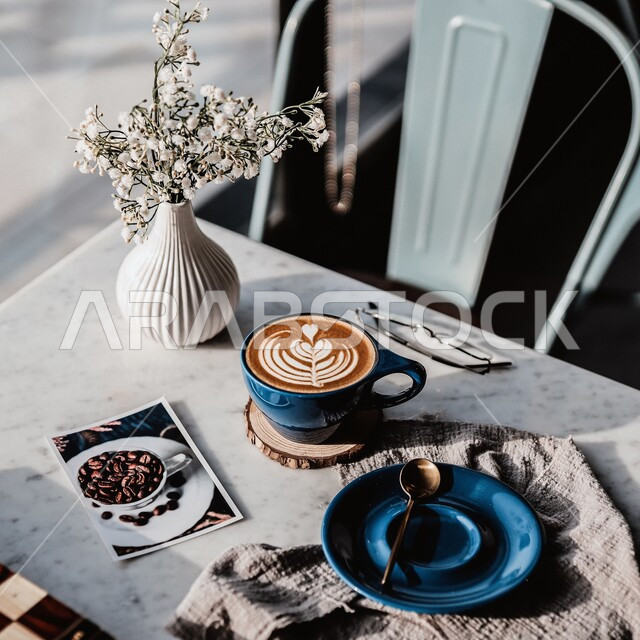  كوب من القهوه برغوة كثيفة مع رسومات على قاعدة خشبية ، مشروبات ساخنة لذيذة ، ديكورات وزينة و أجواء هادئة, مشروب الكابتشينو الساخن ، قهوة اسبرسو, كافيهات ومطاعم في السعودية