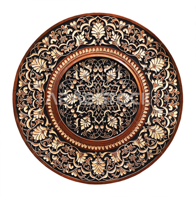 طبق تذكاري بني, زخرفة عربية شرقية منحوتة على طبق خشبي دائري, رسومات و نقوش ذهبية,  خلفية بيضاء
