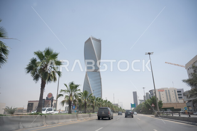 اشجار النخيل الخضراء، البرج المجدول في مدينة الرياض في السعودية، الابراج وناطحات السحاب، حركة مرور السيارات في الطرق والشوارع، الفن الهندسي المعماري، ابراج ومعالم الرياض المشهورة