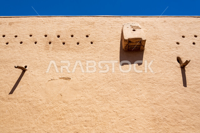 صورة مقربة لجدار طيني بتصاميم عربية قديمة، قصر المصمك التاريخي في مدينة الرياض في السعودية، معالم الرياض التاريخية، الهندسة المعمارية القديمة، اماكن اثرية تراثية سياحية في السعودية