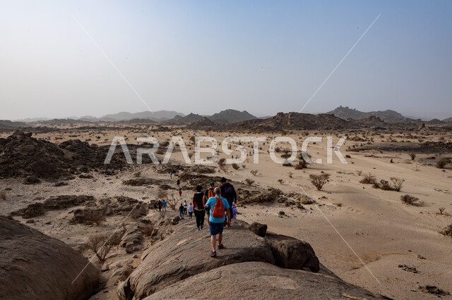 Hiking, a group of young Saudi Gulf Arabs climbing mountains, walking in the desert, the Moon Mountains in the city of Jeddah in the Kingdom of Saudi Arabia, mountain peaks and heights, mountain stones and rocks, tourist places in Saudi Arabia, recreation