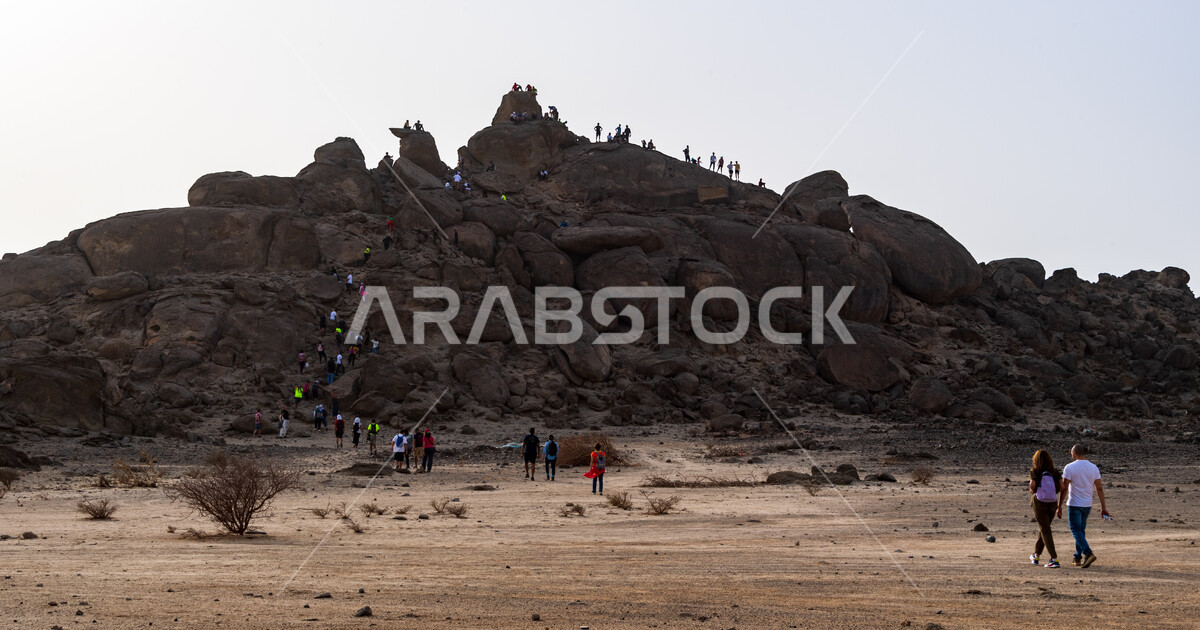 Walking in the desert, a group of Saudi Gulf Arab youth climbing ...