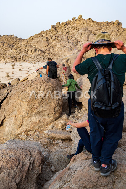 حجارة وصخور جبلية، مجموعة من الشباب العرب الخليجيين السعوديين يتسلقون الجبال، المشي في الصحراء، جبال القمر في مدينة جدة في المملكة العربية السعودية، ممارسة رياضة الهايكنج، قمم ومرتفعات جبلية، اماكن سياحية في السعودية، انشطة بدنية ترفيهية