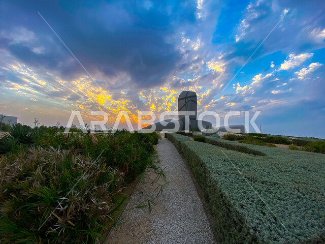 أماكن سياحية في السعودية، زراعة النباتات الخضراء,معالم ثقافية مشهورة، مركز الملك عبدالعزيز الثقافي العالمي في مدينة الظهران في المملكة العربية السعودية، الفن الهندسي المعماري، منظر السماء المليئة بالغيوم البيضاء .