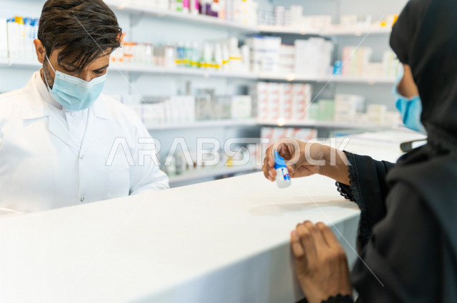  سيدة عربية خليجية سعودية تقوم بتقديم الوصفة الطبية لصيدلي خليجي سعودي ، ارتداء الكمامة الطبية للوقاية من فايروس كورونا ،صرف الادوية الموجودة في الوصفات الطبية ، توفير وتجهيز الادوية اللازمة للمريضة ، بيع الادوية والمستلزمات الطبية ، مهنة الصيدلة