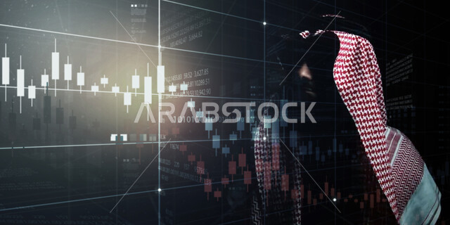رجل اعمال عربي سعودي خليجي أمام شاشة البورصة ، متابعة المؤشرات المالية في السوق المالي ، صعود و نزول البورصة المالية ، الاستثمار المالي و الاقتصادي ، مراقبة الاقتصاد والمعلومات المالية
