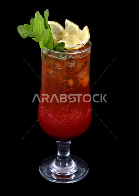 مشروبات باردة و عصائر طبيعية لذيذة , صورة مقربة لعصير الموهيتو بقطع الفواكه الطازجة ، مشروب بشرائح الليمون و النعنع الأخضر ، عصير صحي ومفيد ، كوكتيل صيفي منعش ومثلج ، خلفية سوداء.