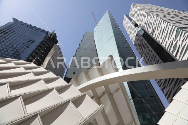 صورة ابداعية بزاوية سفلية لمركز الملك عبدالله المالي ( كافد ) في الرياض، الأبراج وناطحات السحاب و معالم المملكة العربية السعودية المشهورة، تفاصيل الفن الهندسي المعماري وعوالم الجذب السياحة في السعودية. 