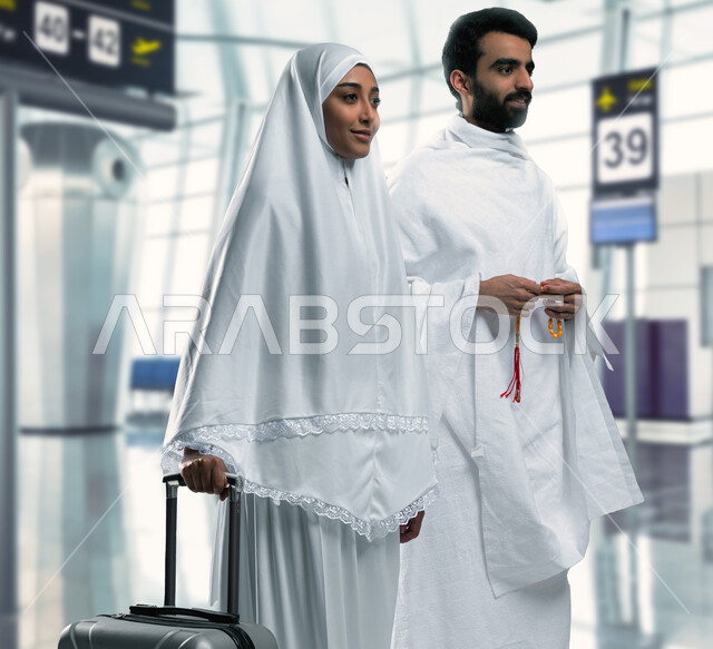 Going to Makkah Al-Mukarramah to perform the rituals of Hajj and Umrah, a Saudi Arab Gulf couple wearing Ihram clothes at the airport, preparing to travel to Makkah Al-Mukarramah, Islam and worship, Hajj season 2023