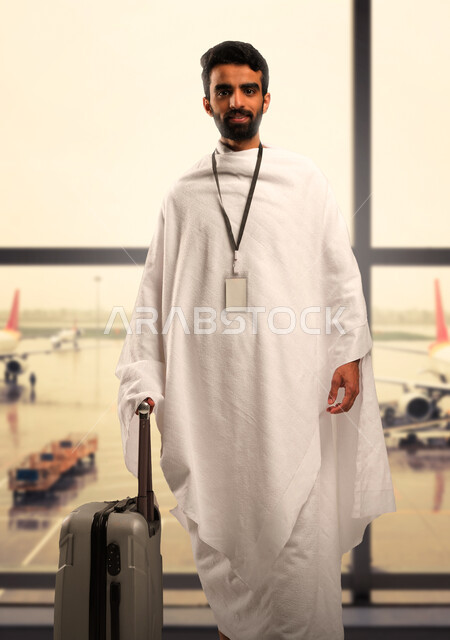  إرتداء بطاقة تعريف بيضاء، الاستعداد للسفر والذهاب لاداء فريضة الحج، شاب مسلم خليجي عربي سعودي يرتدي ملابس الاحرام، الانتظار في المطار، موسم الحج 2023، آداء مناسك الحج والعمرة, إسلاميات وعباده