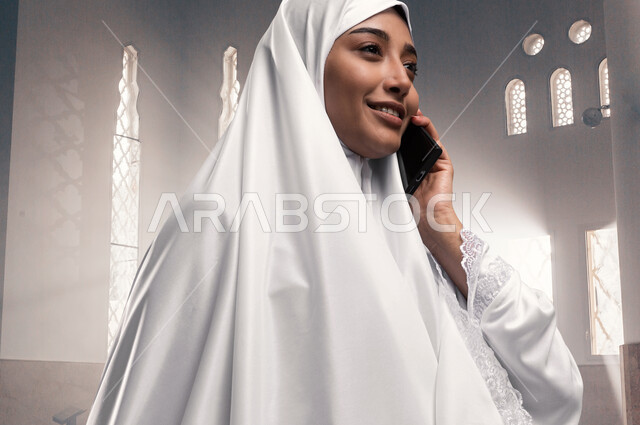 إجراء مكالمه هاتفيه عبر الجوال, إمراه مسلمه خليجيه عربيه سعوديه ترتدي ملابس الاحرام، آداء الصلاه في المسجد, مناسك الحج والعمرة، الركن الخامس من أركان الاسلام، موسم الحج 2023, خلفيه إسلاميه