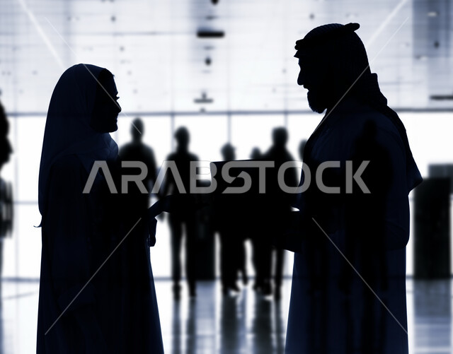 استخدام الحاسوب المحمول، صورة ظلية لفريق عمل عربي خليجي سعودي في إجتماع عمل داخل مقر الشركة، مناقشة اهداف وسياسة الشركة، شرح استراتيجية العمل، تدريب وتطوير الموظفين، بيئة عمل سعودية