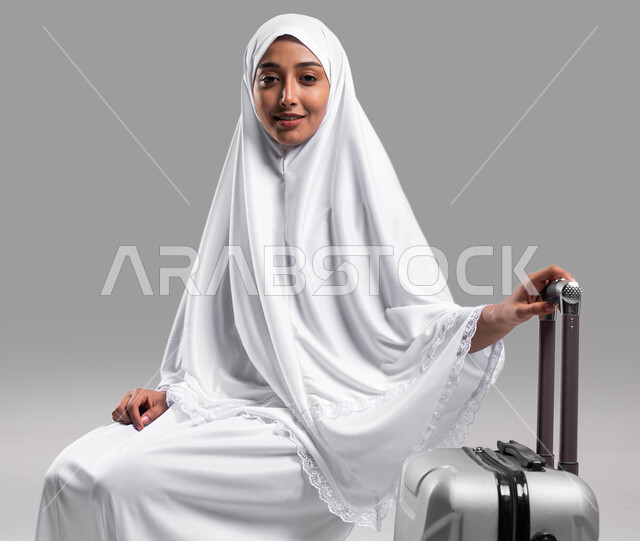 Visiting the Sacred House of God in Makkah Al-Mukarramah, preparing and preparing to travel to perform the rituals of Hajj and Umrah 2023, drawing closer to God by performing acts of worship, a portrait of a Saudi Arabian Gulf Muslim woman wearing Ihram c