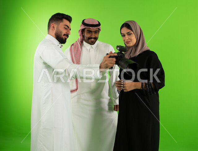 مراجعة واختيار أفضل الصور من الكاميرا، مصور عربي سعودي خليجي يقوم بانتقاء الصور الفوتوغرافية مع العارضين، كروما جلسة تصوير في الاستوديو، خلفية شاشة خضراء، كاميرات إلكترونية متطورة، خلف الكواليس