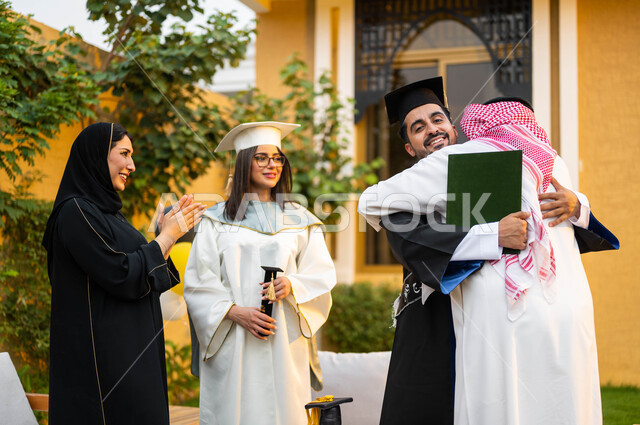 الاحتفال بالتخرج في احدى الشاليهات السياحية في السعودية، اب عربي خليجي سعودي يحتضن ابنه فرحا بتخرجه، خريج وخريجة جامعيين يرتديان ملابس التخرج ويمسكان شهادة النجاح والتفوق، عائلة سعودية خليجية عربية سعيدة، التعليم في السعودية
