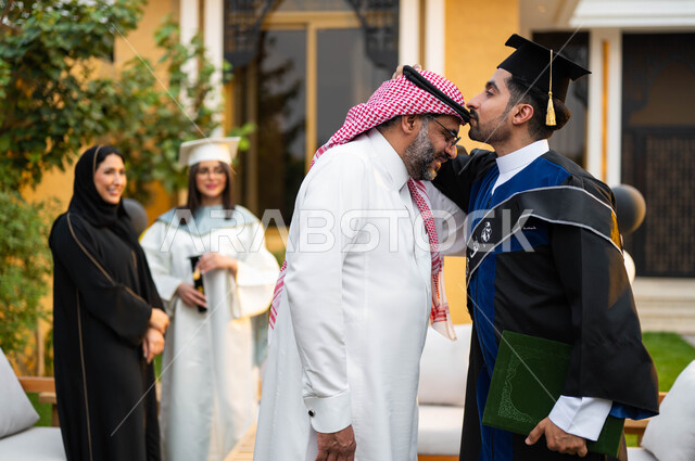 شاب عربي خليجي سعودي يقوم بتقبيل راس والده، خريج وخريجة جامعيين يرتديان ملابس التخرج ويمسكان شهادة النجاح والتفوق، عائلة سعودية خليجية عربية سعيدة، الاحتفال بالتخرج في احدى الشاليهات السياحية في السعودية، التعليم في السعودية