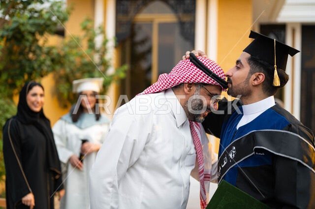 الاحتفال بالتخرج في احدى الشاليهات السياحية في السعودية، شاب عربي خليجي سعودي يقوم بتقبيل راس والده، خريج وخريجة جامعيين يرتديان ملابس التخرج ويمسكان شهادة النجاح والتفوق، عائلة سعودية خليجية عربية سعيدة، التعليم في السعودية