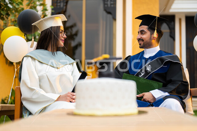 ايماءات وجه تدل على السعادة، كيكة الاحتفال بالتخرج، خريج وخريجة جامعيين سعوديان خليجيان عربيان يرتديان ملابس التخرج ويمسكان شهادة النجاح والتفوق، الاحتفال بالتخرج في احدى الشاليهات السياحية في السعودية، التعليم في السعودية