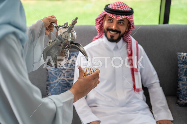 ايماءات تدل على السعاده ,حسن اكرام و استقبال الضيف, صورة مقربة لإمرأة عربيه خليجية سعودية تقوم بتقديم القهوة للضيوف, أعياد ومناسبات اسلامية, أجواء العيد في المجتمع العربي السعودي, التجمعات والزيارات الاسرية في عيد الاضحى المبارك .