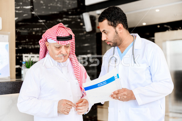 طبيبان عربيان خليجيان سعوديان يعملان داخل المستشفى ، يتبادلان الاستشارات الطبية ، مراجعة تقارير الحالات المرضية، العمل الجماعي للأطباء الاخصائيين في المستشفى ، مفهوم الطب والرعاية الصحية