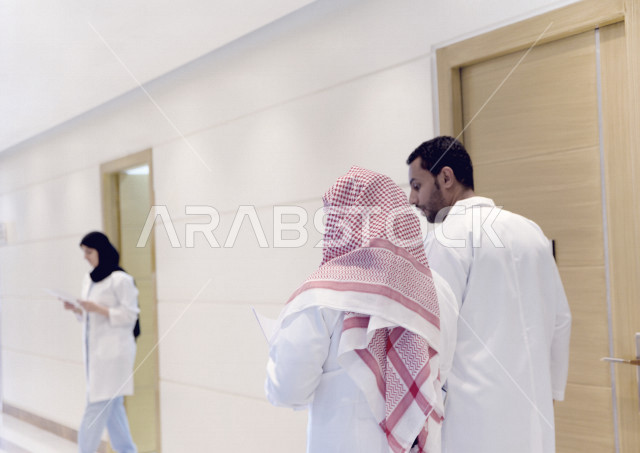 طبيبان عربيان خليجيان سعوديان يتجولان داخل المستشفى ، جولة تفقدية للاقسام ، يتبادلان الاستشارات الطبية ، مراجعة تقارير الحالات المرضية، العمل الجماعي للأطباء الاخصائيين في المستشفى ، مفهوم الطب والرعاية الصحية